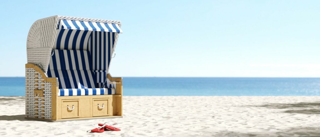 Leerer Strandkorb am Strand der Ostsee oder Nordsee in Deutschland als Sommerurlaub Konzept